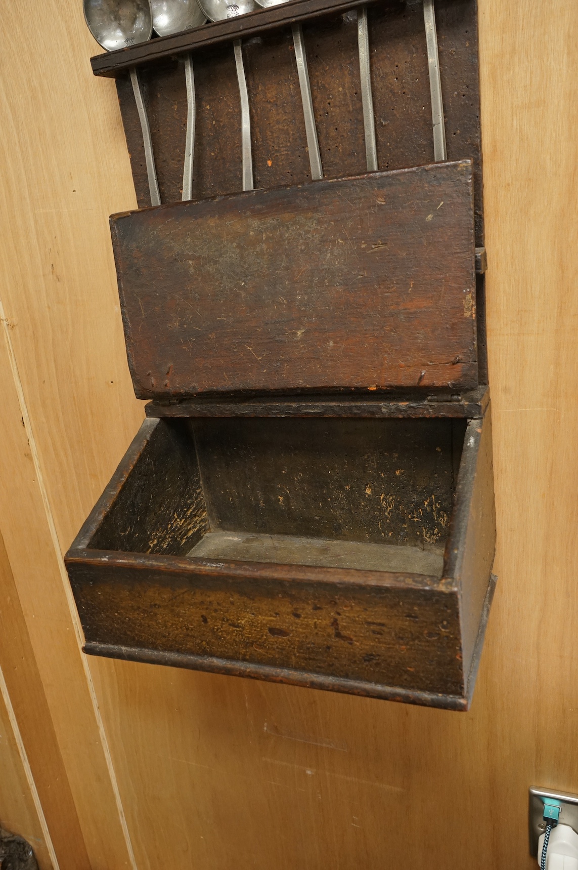 An 18th century oak spoon rack and collection of pewter spoons, 55cm high. Condition - wood cracked